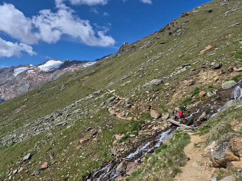 am Ramolfernerbach wird das Ramolhaus gesichtet; der Bach fließt mit einem Versatz zur Falllinie westlicher als die Lage des Ferners zu Tal; ideal zum Fassen frischen Wassers