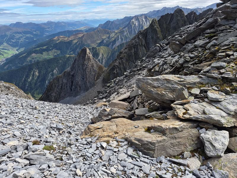 links Sedimentgestein, rechts Kristallingestein; die gelblichen bis ockerfarbenen Kalkschiefer der Schönach-Mulde liegen als schmale Grenzschicht dazwischen