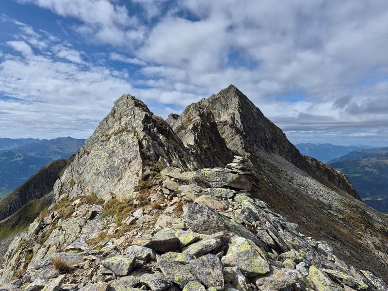 Rückblick auf das En de der flachen Gratstrecke nach dem Inneren Falk; Steinmann mit Richtungsanzeige des zuoberst gesetzten Steines